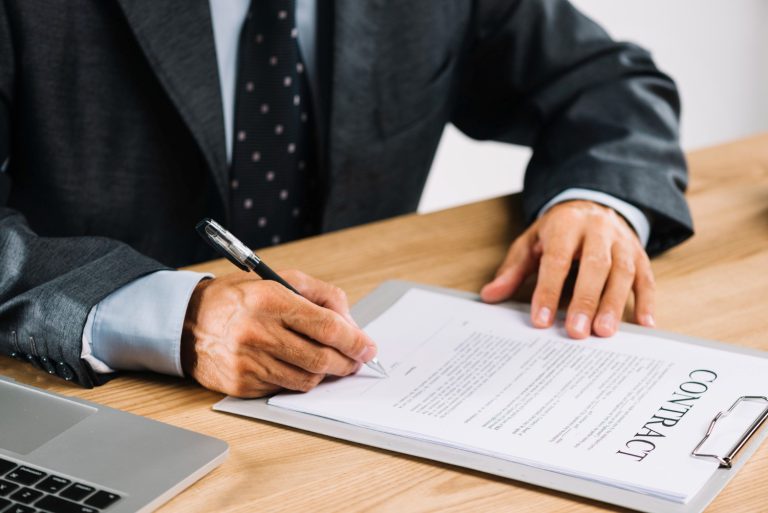 male-lawyer-signing-contract-with-pen-clipboard